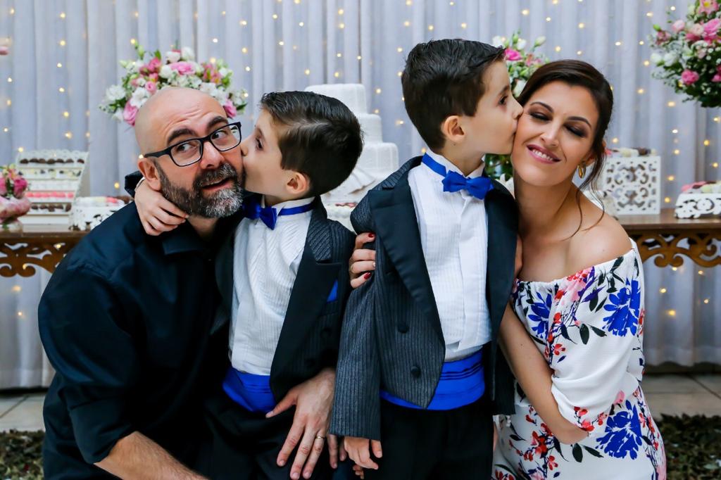 gêmeos autistas de 7 anos beijando o pai e a mãe